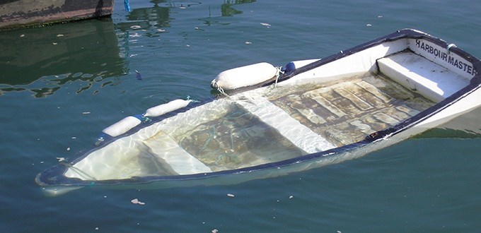 Liten robåt som ligger under vann. Illustrasjonsbilde