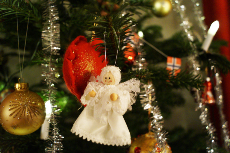 utsnitt pyntet juletre med en engel, julekule, hjerte lys og flagg